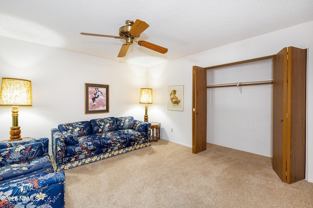 living room featuring ceiling fan, carpet flooring, and a textured ceiling