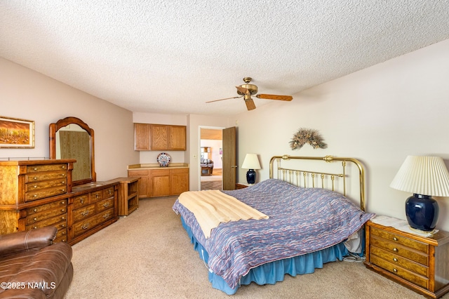 bedroom featuring light carpet, a ceiling fan, and a textured ceiling