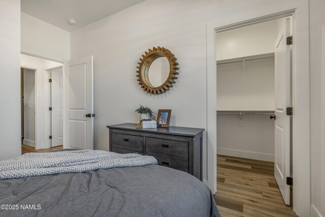 7939 N Red Lake Rd, Williams, AZ 86046 - bedroom with a walk in closet, wood finished floors, and a closet