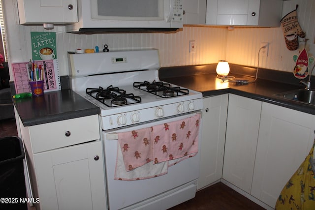 kitchen with white appliances, sink, and white cabinets