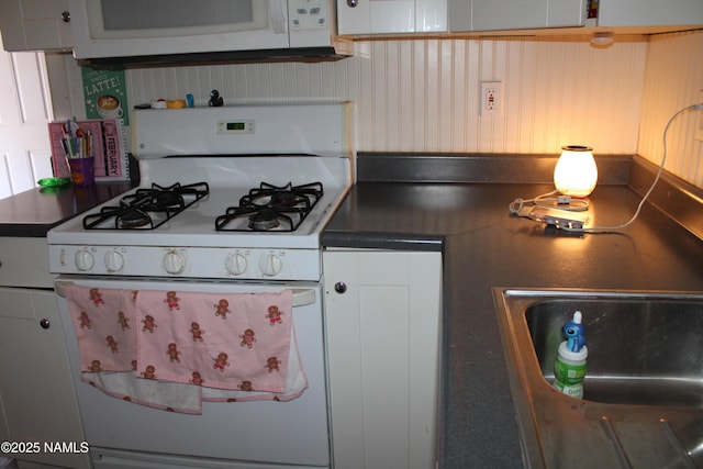 kitchen featuring sink, white appliances, and white cabinets