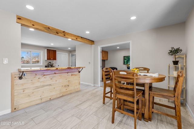 dining area featuring beam ceiling