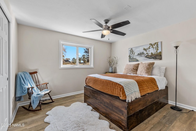 bedroom with hardwood / wood-style floors, a closet, and ceiling fan