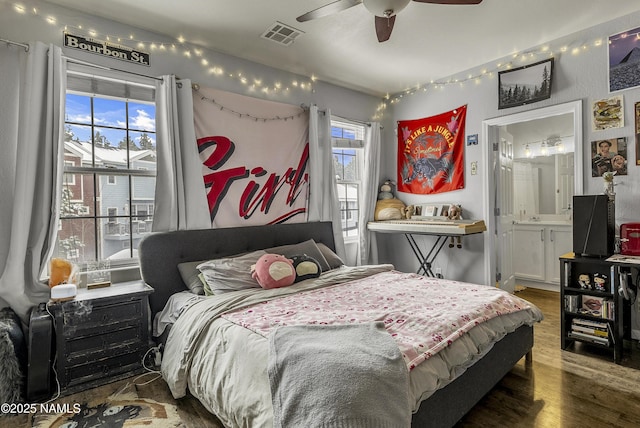 bedroom featuring wood finished floors, a ceiling fan, and visible vents