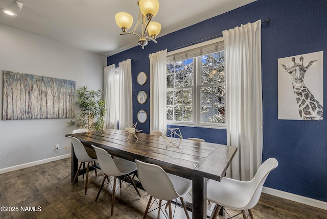 dining room featuring wood finished floors, a chandelier, and baseboards