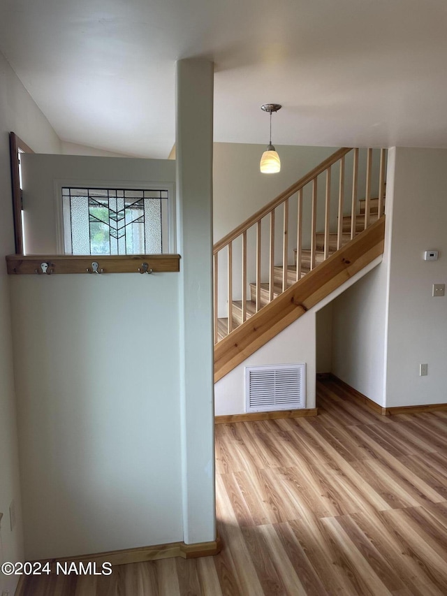 stairs featuring hardwood / wood-style flooring and vaulted ceiling