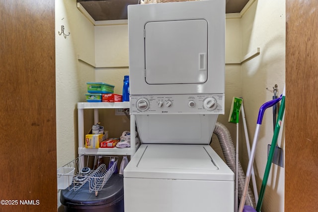 washroom featuring a textured wall, laundry area, and stacked washing maching and dryer