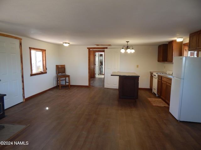 kitchen with dark hardwood / wood-style flooring, decorative light fixtures, a wood stove, white appliances, and a kitchen island