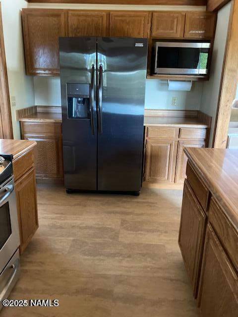 8355 N Stony Mountain Way, Flagstaff, AZ 86001 - kitchen featuring stainless steel appliances, light wood finished floors, brown cabinets, and light countertops
