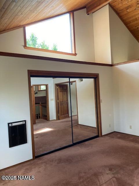 8355 N Stony Mountain Way, Flagstaff, AZ 86001 - unfurnished bedroom with carpet, heating unit, wood ceiling, high vaulted ceiling, and a closet