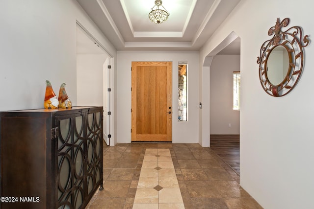 foyer featuring a raised ceiling