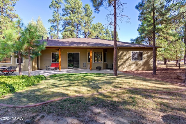 back of house featuring a patio area and a lawn