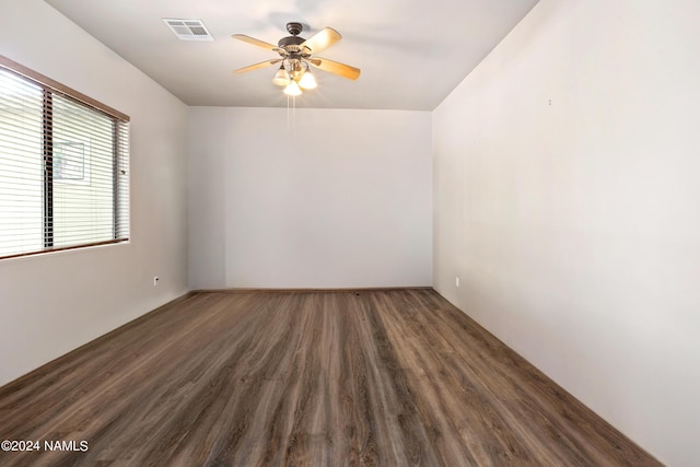 spare room featuring dark wood-type flooring and ceiling fan