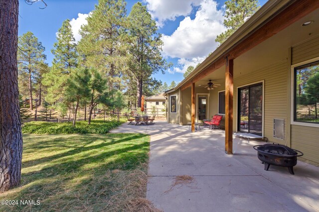 view of yard featuring an outdoor fire pit, a patio area, and ceiling fan