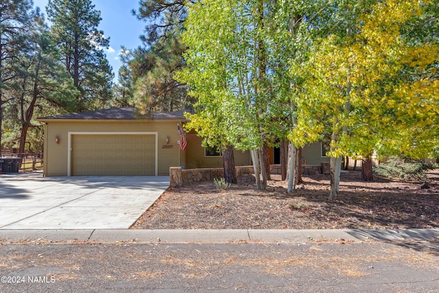 view of property hidden behind natural elements featuring a garage