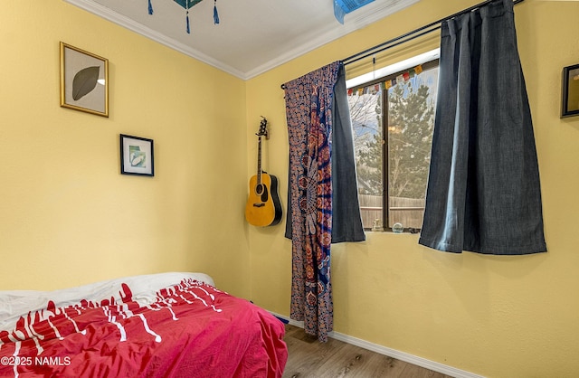 bedroom with ornamental molding and wood-type flooring