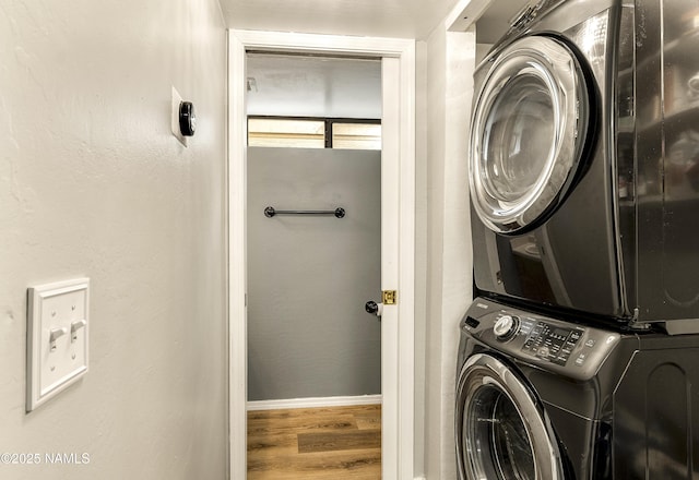 washroom featuring stacked washer and clothes dryer and hardwood / wood-style floors