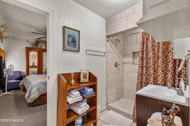 bathroom featuring a textured ceiling, walk in shower, and vanity