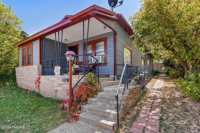 view of front facade with covered porch and cooling unit