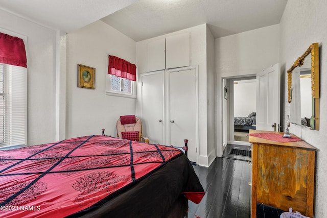 bedroom featuring a textured ceiling, a closet, and dark hardwood / wood-style flooring