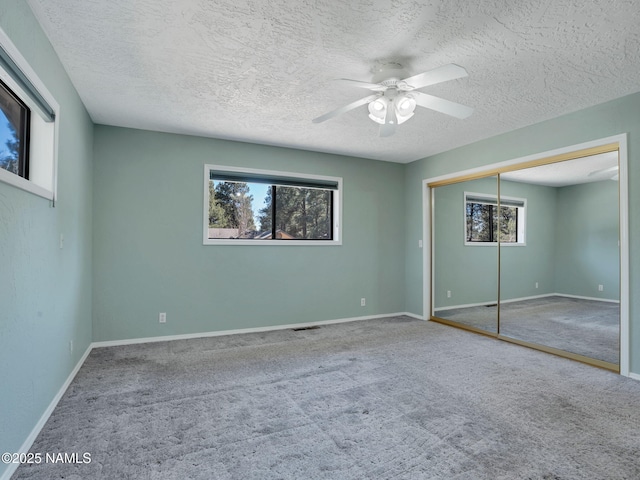 3792 E Ramble Wood Dr, Flagstaff, AZ 86004 - unfurnished bedroom with a closet, carpet flooring, a textured ceiling, baseboards, and ceiling fan