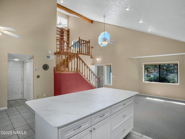 3792 E Ramble Wood Dr, Flagstaff, AZ 86004 - kitchen with light stone counters, white cabinetry, open floor plan, visible vents, and ceiling fan