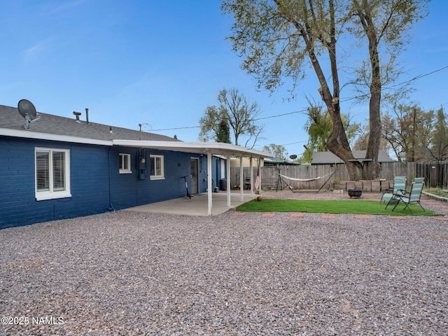 2821 N Tindle Blvd, Flagstaff, AZ 86004 - back of property featuring brick siding, a fenced backyard, an outdoor fire pit, and a patio area