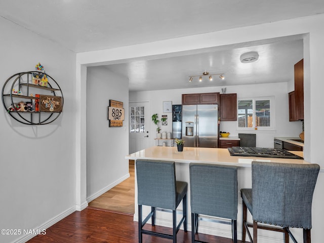 2821 N Tindle Blvd, Flagstaff, AZ 86004 - kitchen with a peninsula, a kitchen breakfast bar, stainless steel fridge, gas cooktop, and dark wood finished floors