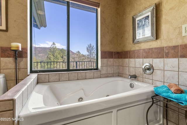 bathroom featuring a jetted tub and tile walls