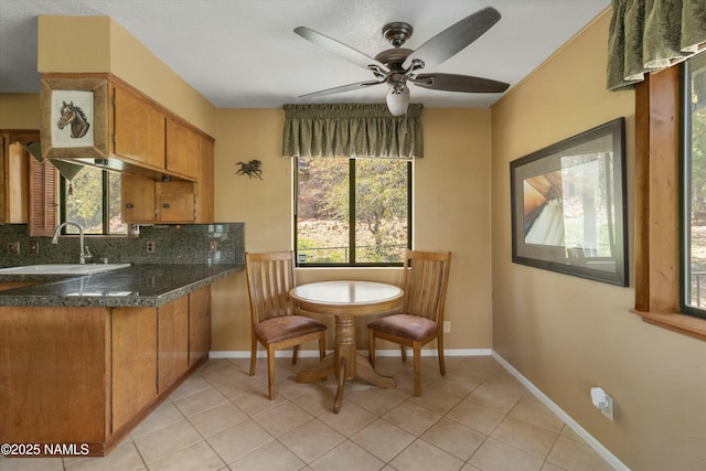 dining space with baseboards, a ceiling fan, and light tile patterned flooring