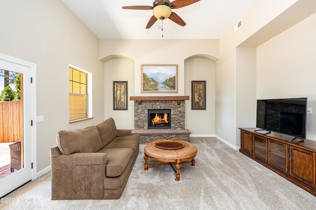 living room featuring ceiling fan, light colored carpet, and a fireplace