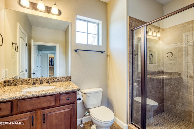 bathroom featuring toilet, vanity, and walk in shower