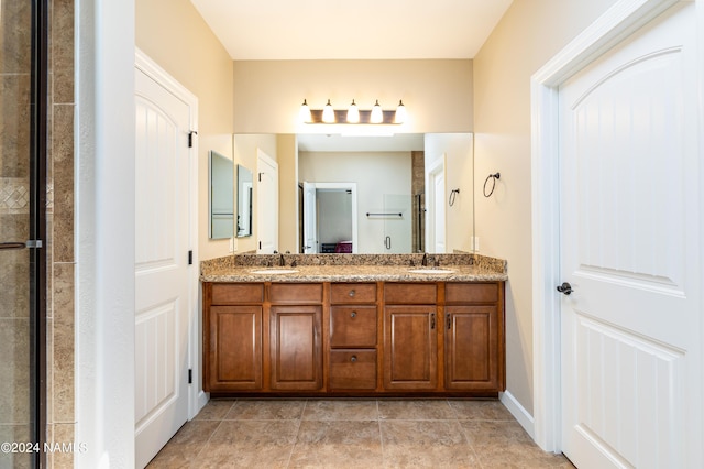 bathroom featuring tile patterned flooring, vanity, and a shower with shower door