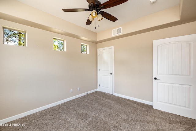 carpeted spare room with ceiling fan and plenty of natural light