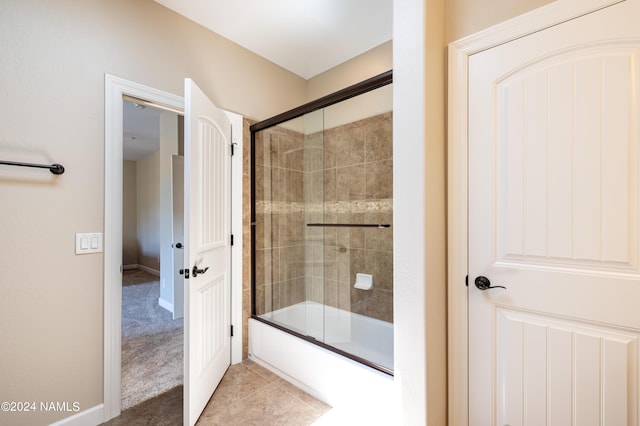 bathroom with shower / bath combination with glass door and tile patterned flooring