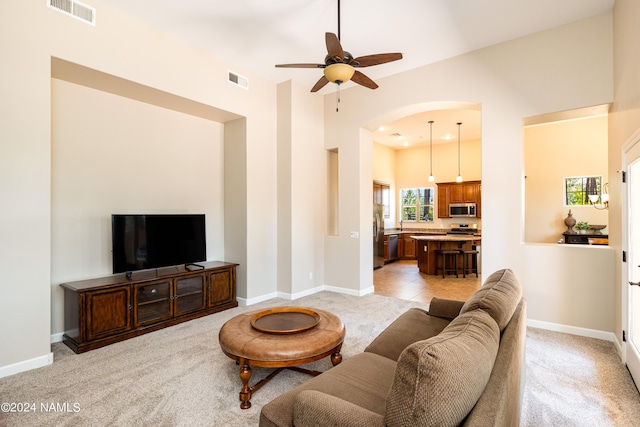 living room with light carpet and ceiling fan