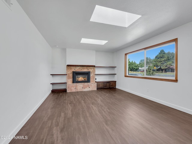 unfurnished living room featuring a skylight and dark wood-type flooring