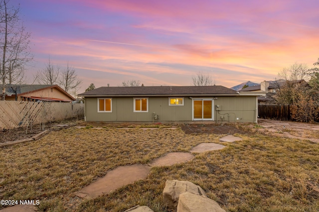 back house at dusk with a yard