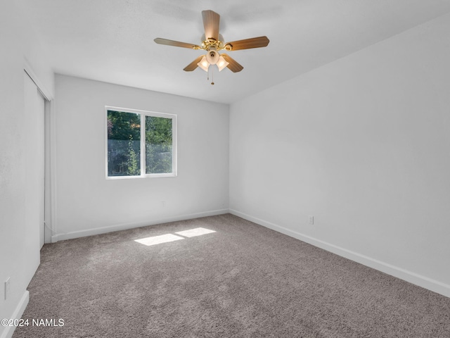 unfurnished room with ceiling fan and carpet flooring