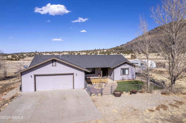 6162 Meadows Ln, Flagstaff, AZ 86004 - ranch-style house featuring a garage, concrete driveway, a mountain view, and fence