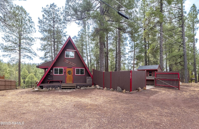 exterior space with an outbuilding, driveway, and fence