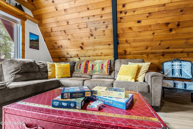 living room featuring lofted ceiling, wood finished floors, and wooden walls