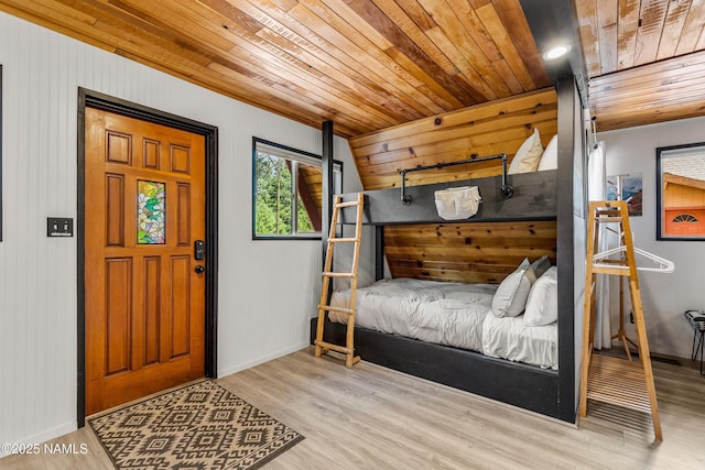 bedroom with baseboards, wood finished floors, and wood ceiling