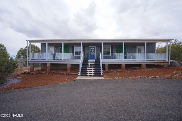 view of front of home featuring covered porch and stairs
