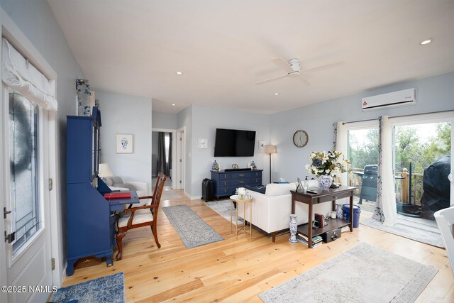 living room with a ceiling fan, light wood-style floors, a wall mounted air conditioner, and recessed lighting