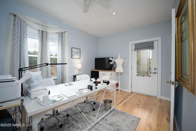 office area with baseboards, light wood-style flooring, and a ceiling fan