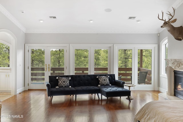 1430 E Puma Pl Unit F, Munds Park, AZ 86017 - living area with healthy amount of natural light, french doors, wood-type flooring, a premium fireplace, and crown molding