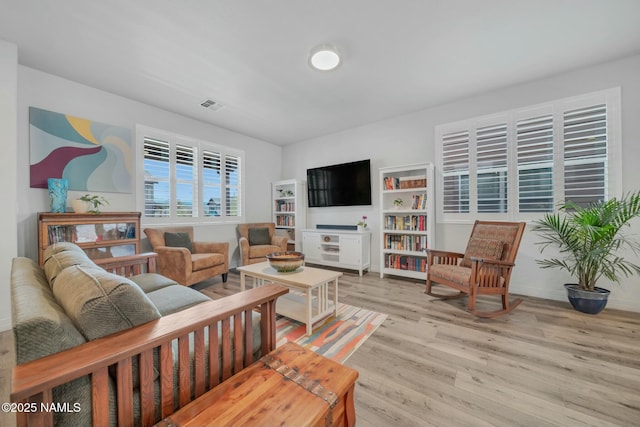 living area with visible vents, baseboards, and light wood-style floors