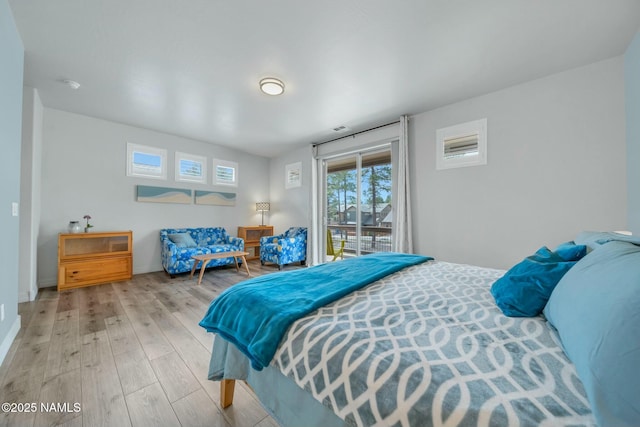 bedroom with access to outside, wood finished floors, and baseboards