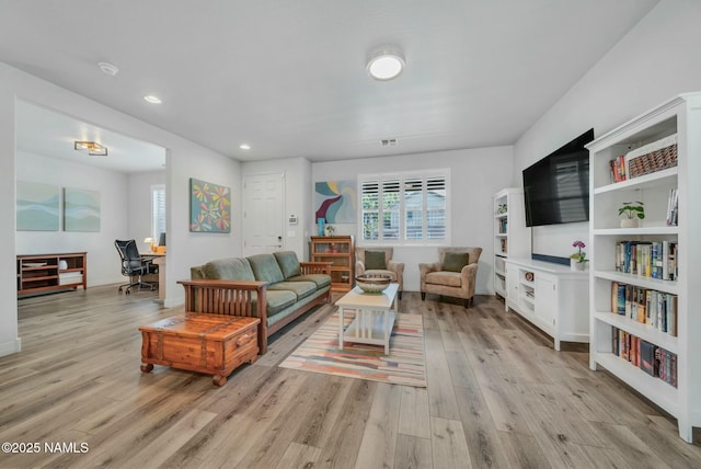 living area featuring recessed lighting, light wood-type flooring, and visible vents